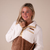 Woman holding the neckline of her pullover.