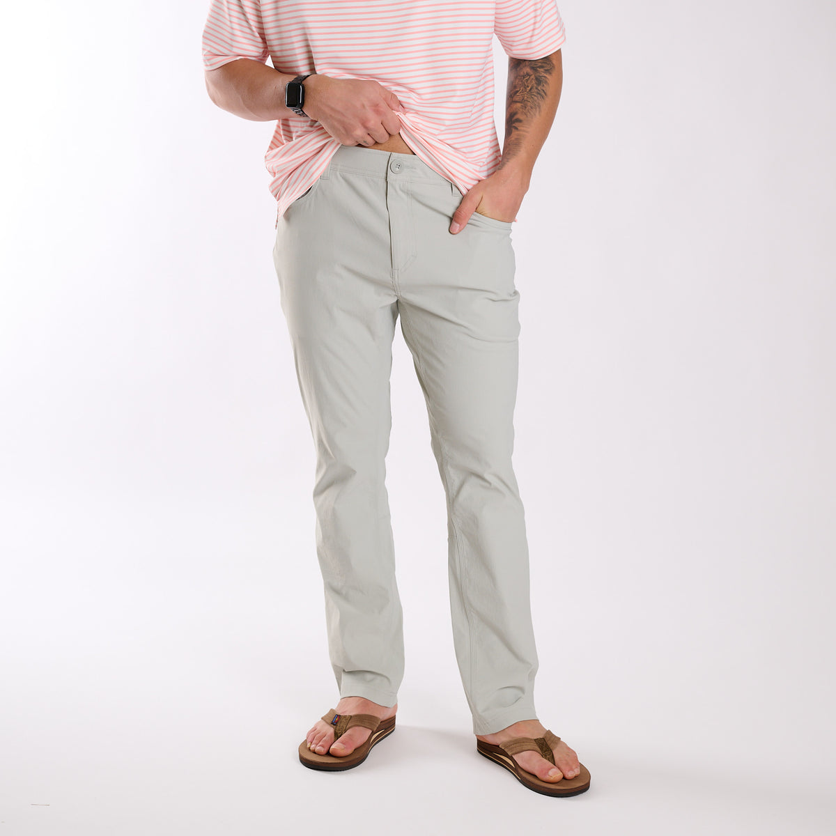 Man wearing Local Boy Outfitters Commuter Pants 2.0 in Cool Grey standing in front of a white background.