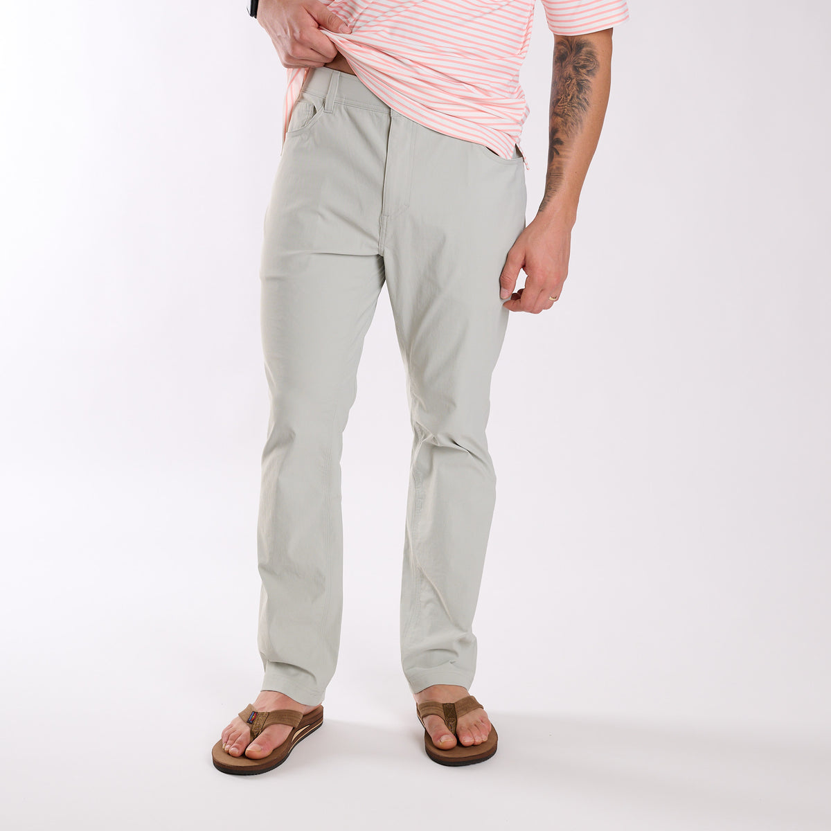Man wearing Local Boy Outfitters Commuter Pants 2.0 in Cool Grey standing in front of a white background.