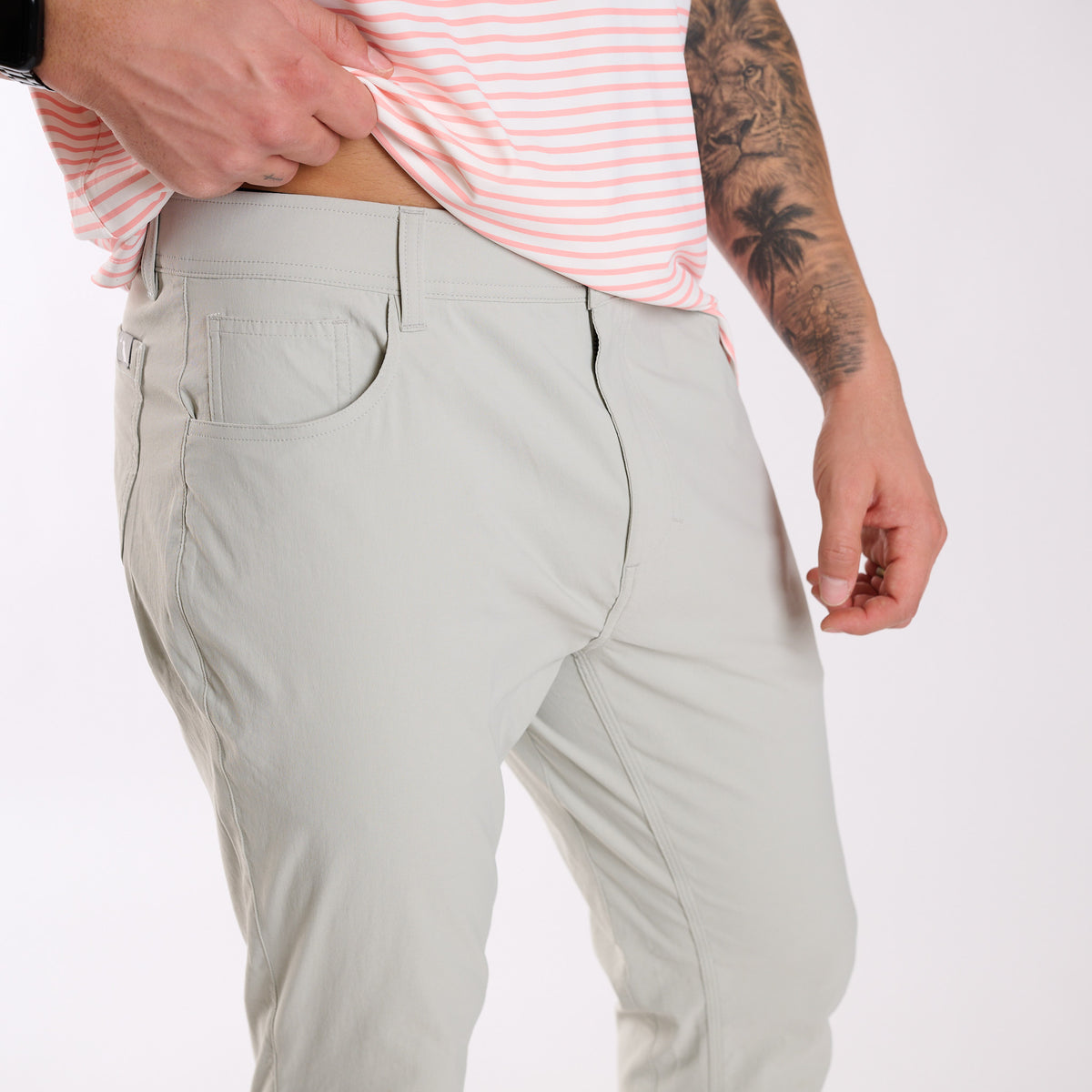 Man wearing Local Boy Outfitters Commuter Pants 2.0 in Cool Grey standing in front of a white background.