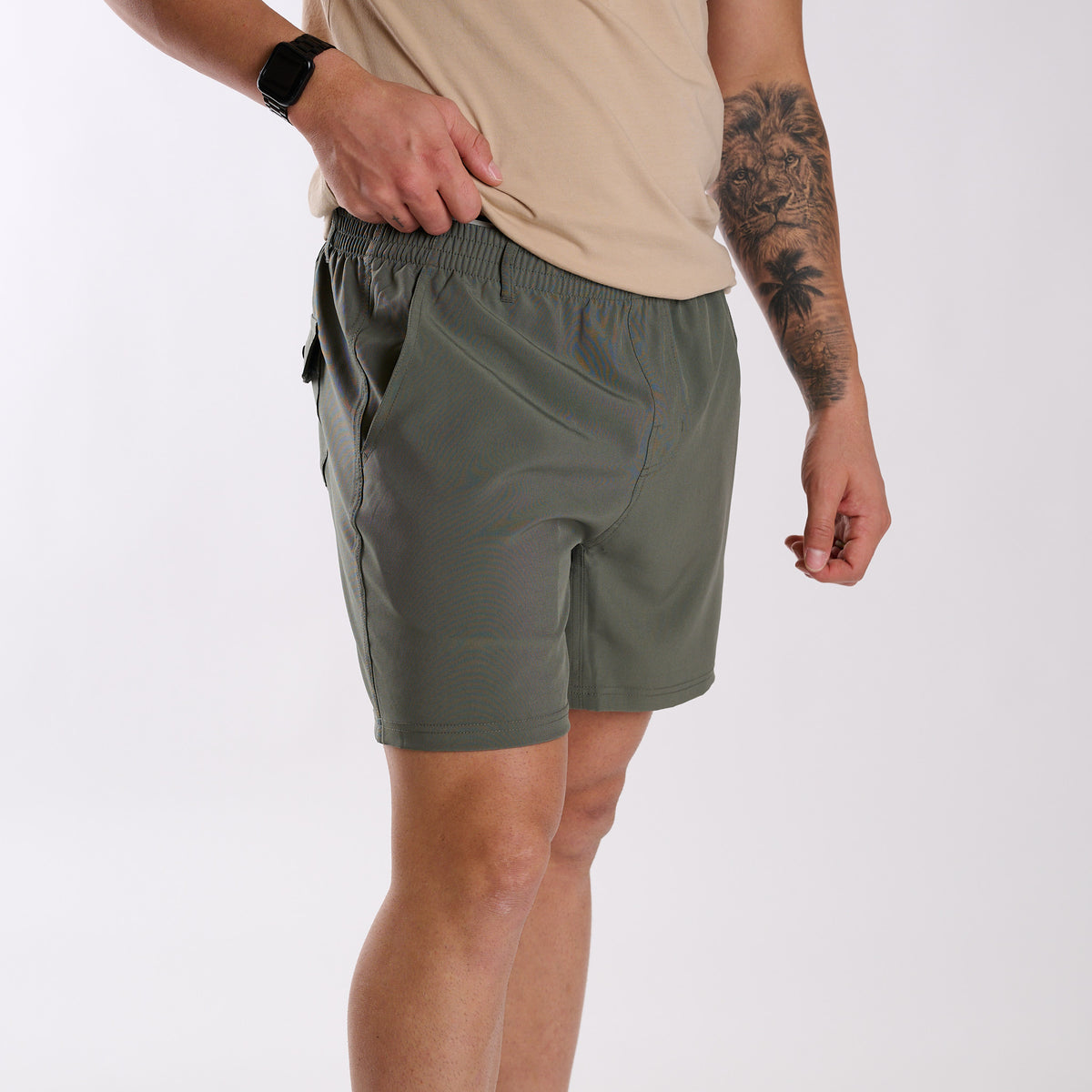 Man wearing Local Boy Outfitters Volley Shorts in Olive Green with a 6" inseam standing in front of a white background