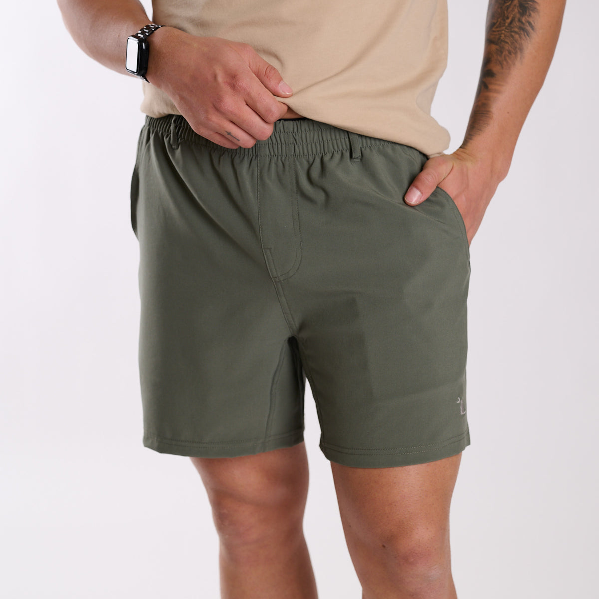 Man wearing Local Boy Outfitters Volley Shorts in Olive Green with a 6" inseam standing in front of a white background