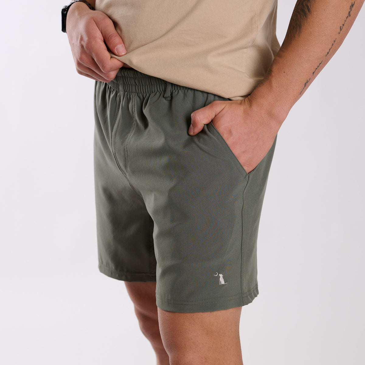 Man wearing Local Boy Outfitters Volley Shorts in Olive Green with a 6" inseam standing in front of a white background