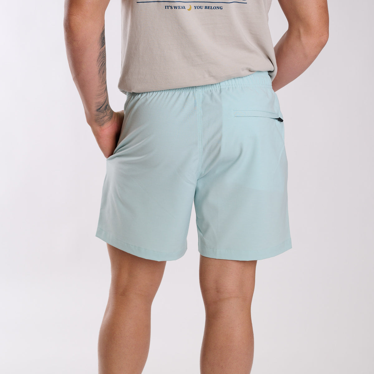 Man wearing Local Boy Outfitters Bayview Swim Trunks in Mint in front of a white backdrop.