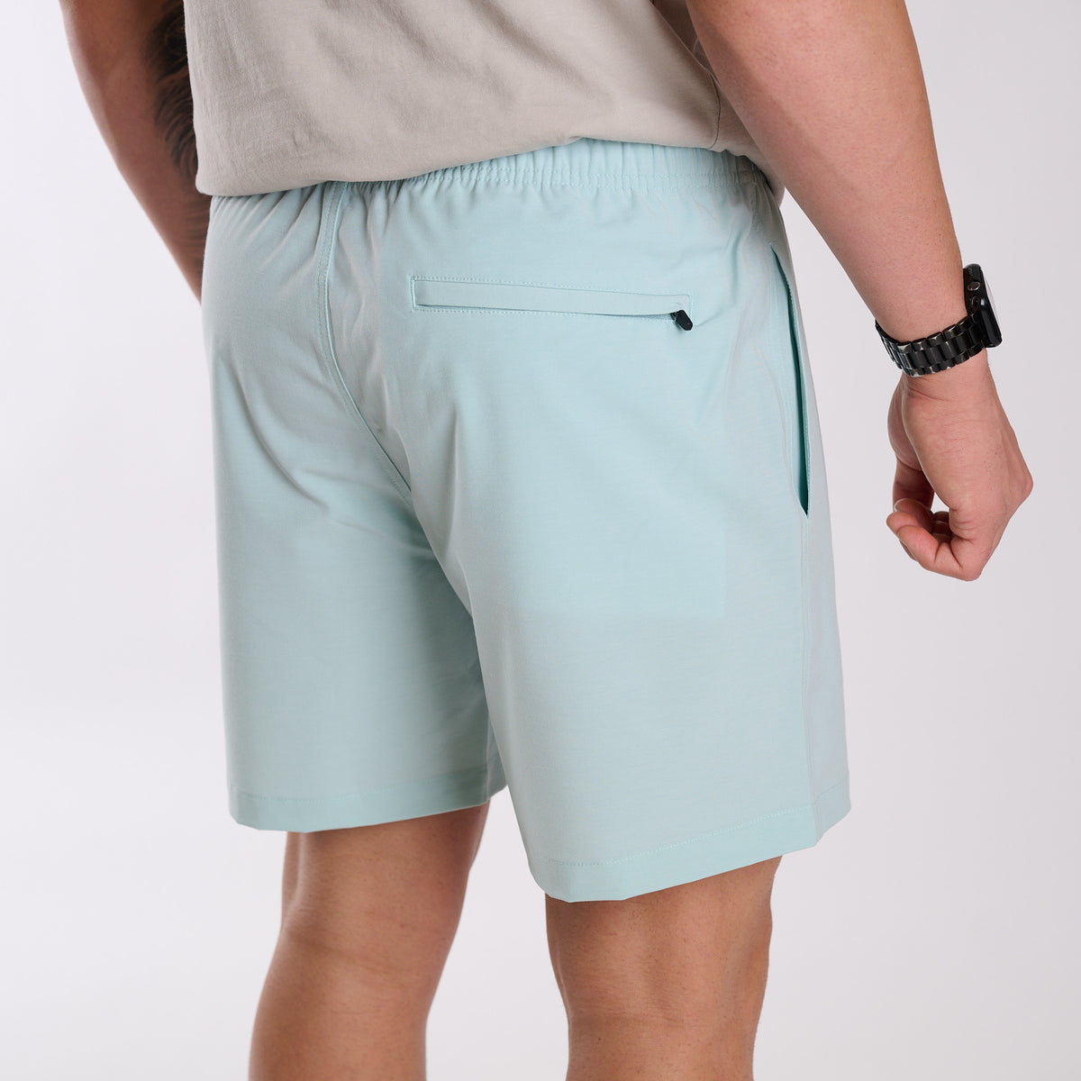 Man wearing Local Boy Outfitters Bayview Swim Trunks in Mint in front of a white backdrop.