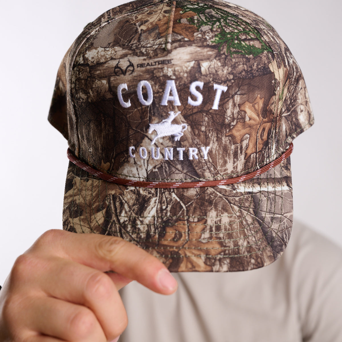 Camouflage cap with 'COAST COUNTRY' branding on a plain background