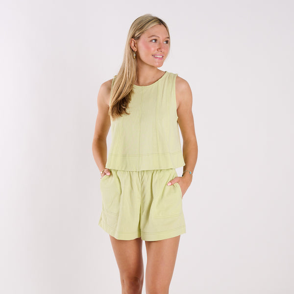  Woman wearing a light green sleeveless top and shorts set on a white background