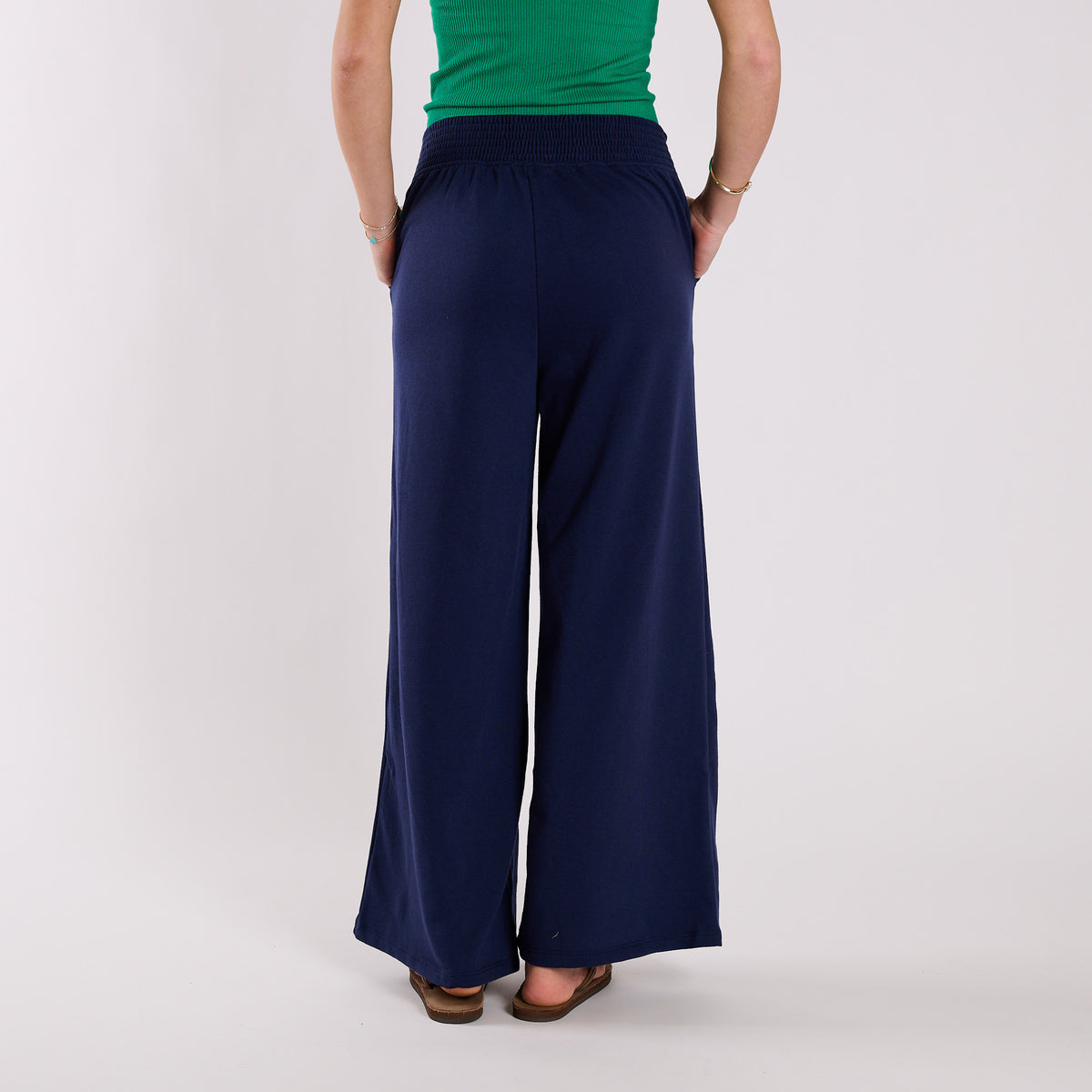 Navy wide-leg pants worn by a person on a white background