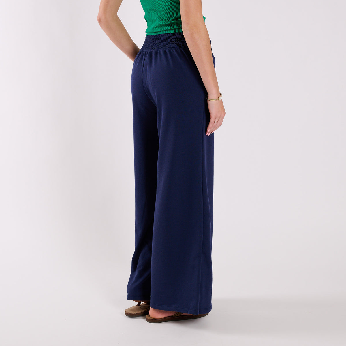 Navy wide-leg pants worn by a person on a white background