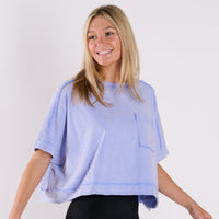 Woman wearing a boxy t-shirt on a grey background.