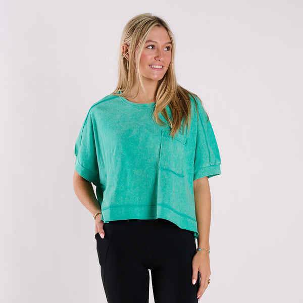  Woman wearing an orange oversized cropped shirt and black pants on a white background