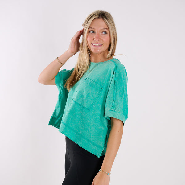  Woman wearing an orange oversized cropped shirt and black pants on a white background