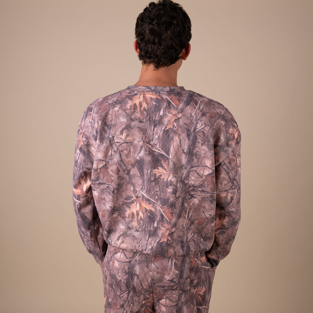 Person wearing a camouflage outfit on a beige background