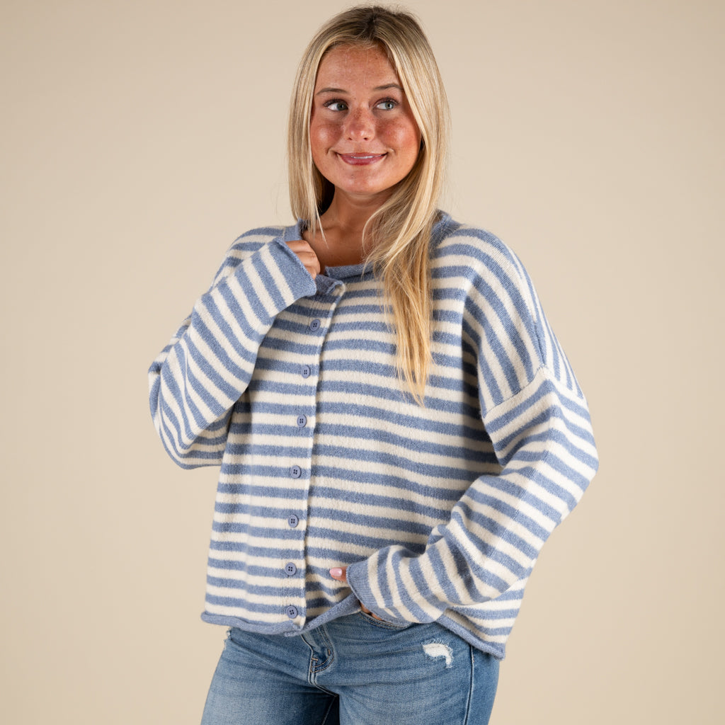 Woman wearing a blue and white striped sweater against a beige background