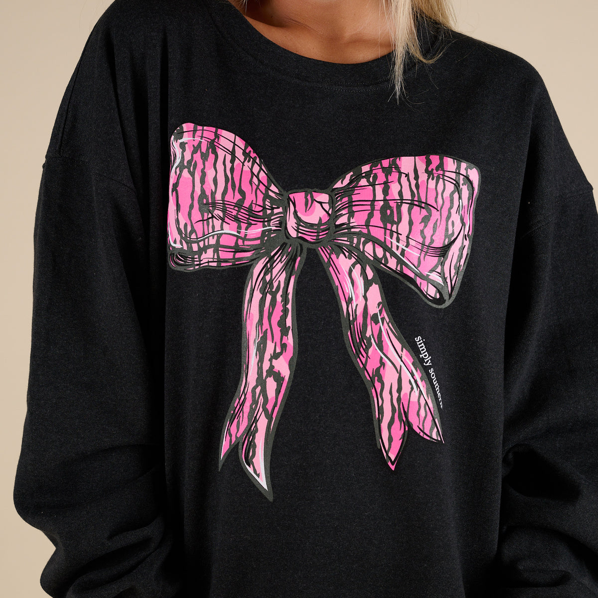 black simply southern sweatshirt with large pink camo bow on the front.