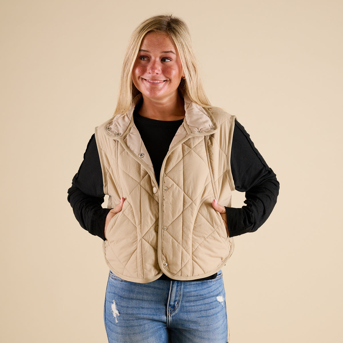 Blu Pepper Quilted Light Snap Vest in Khaki shown on model wearing a black long sleeve top and jeans, featuring quilted detailing and snap-front closure