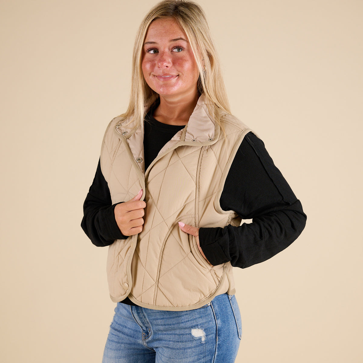 Blu Pepper Quilted Light Snap Vest in Khaki shown on model wearing a black long sleeve top and jeans, featuring quilted detailing and snap-front closure