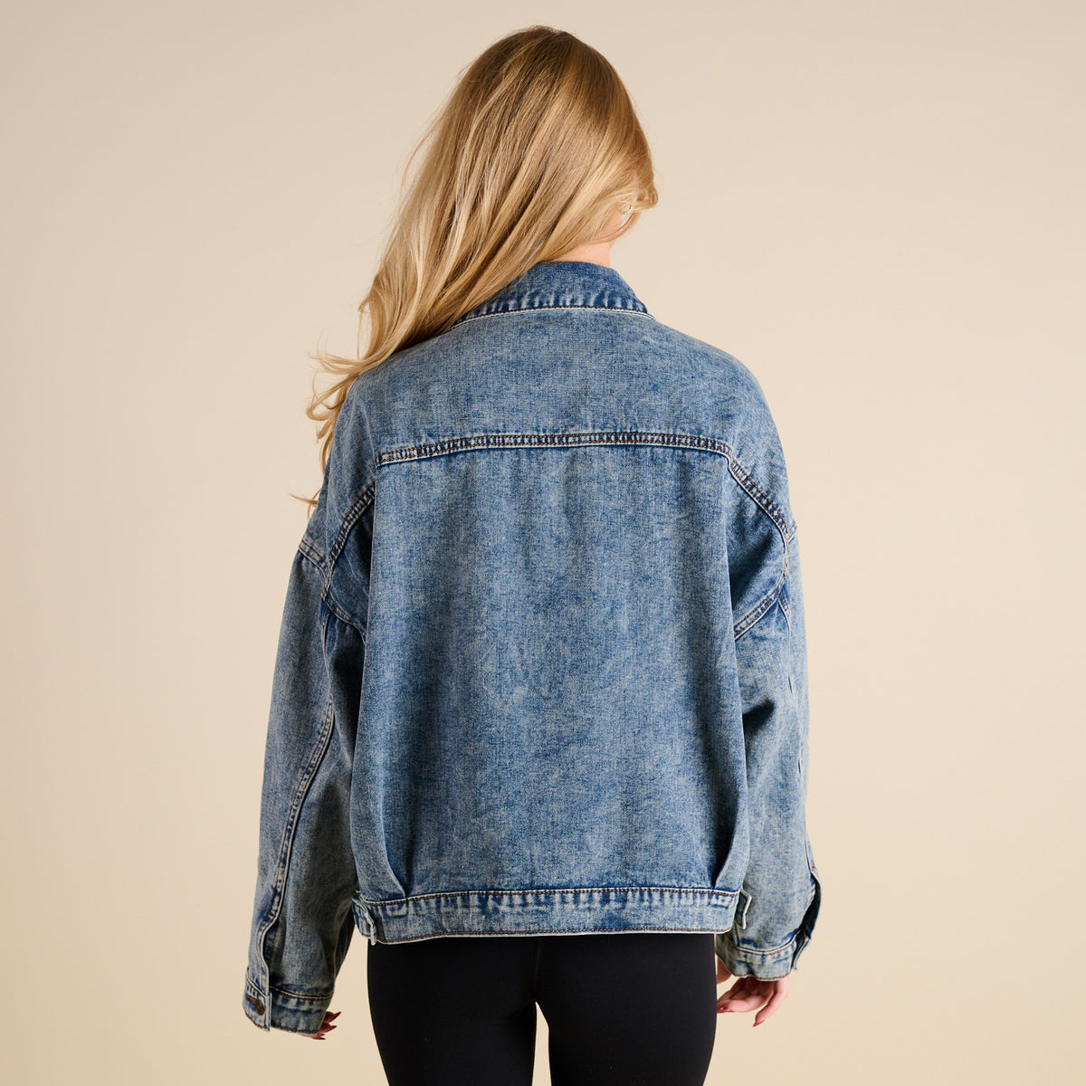 Woman wearing Dark Wash Denim Jacket by Rivalry Runway on a beige background