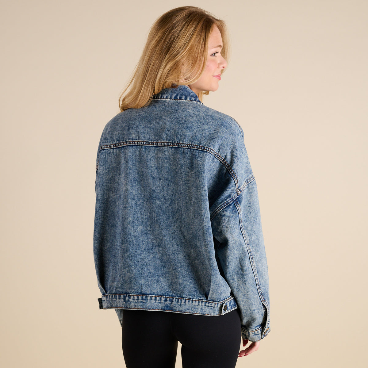 Woman wearing Dark Wash Denim Jacket by Rivalry Runway on a beige background