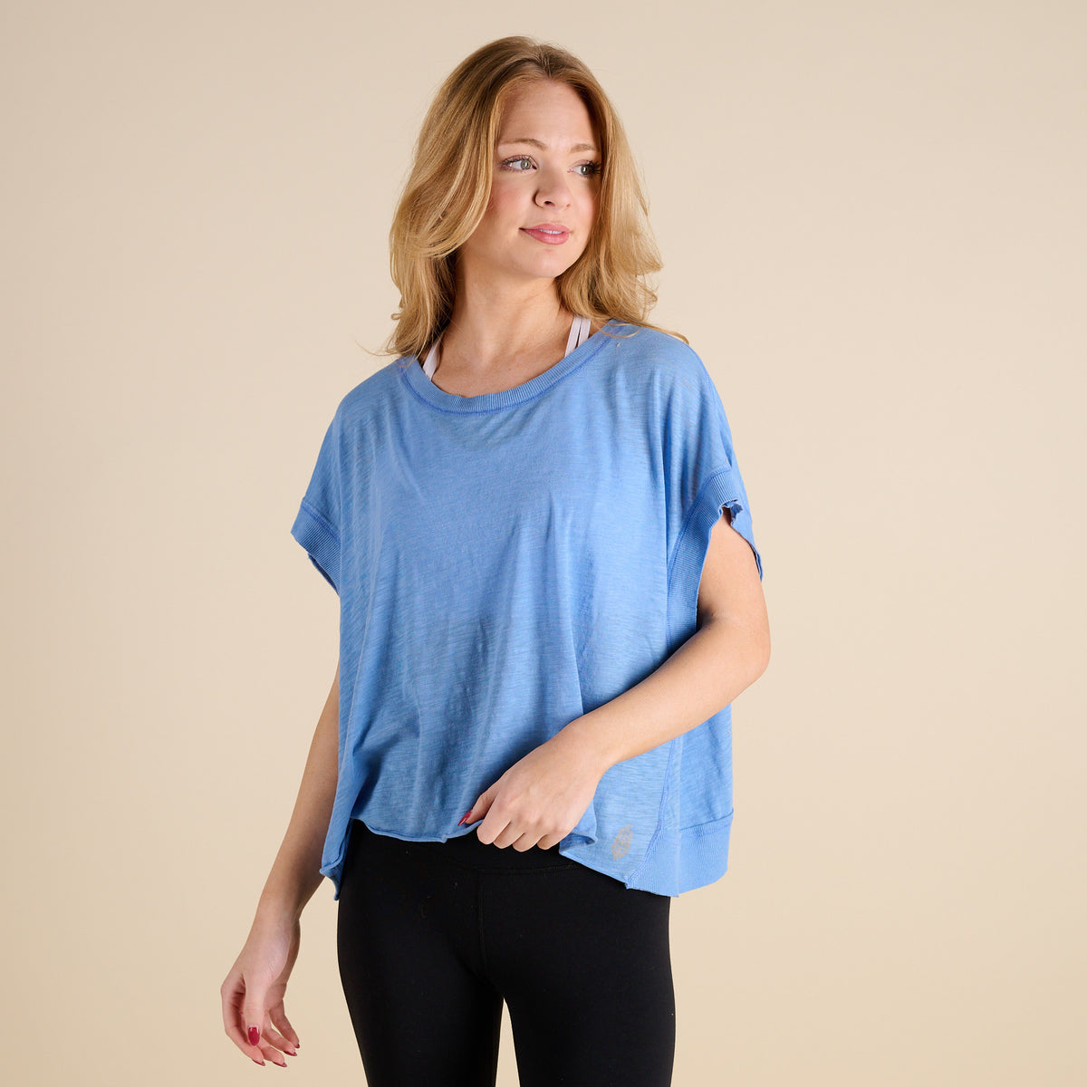 woman wearing FP Movement My Time Tee in Denim on beige background