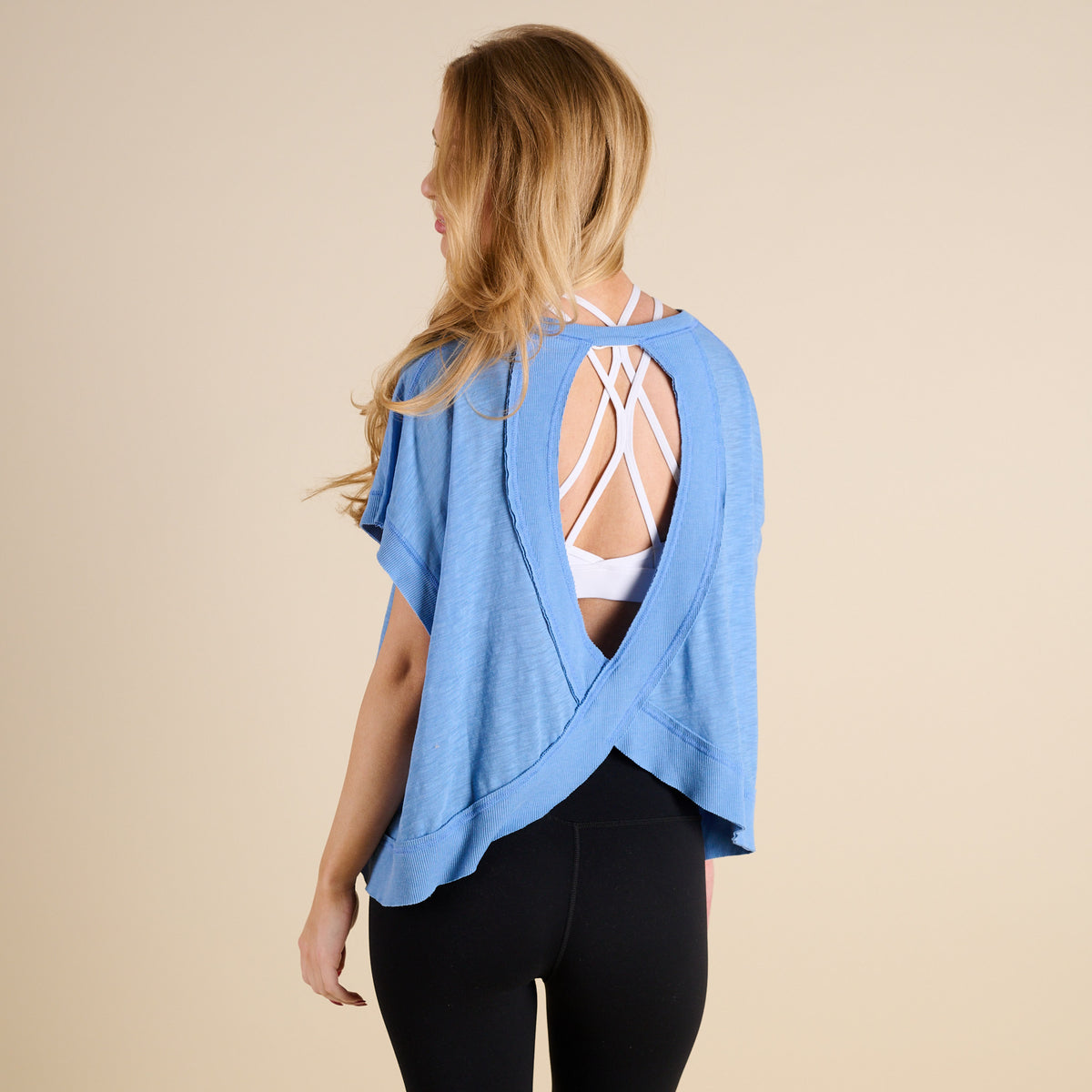 woman wearing FP Movement My Time Tee in Denim on beige background