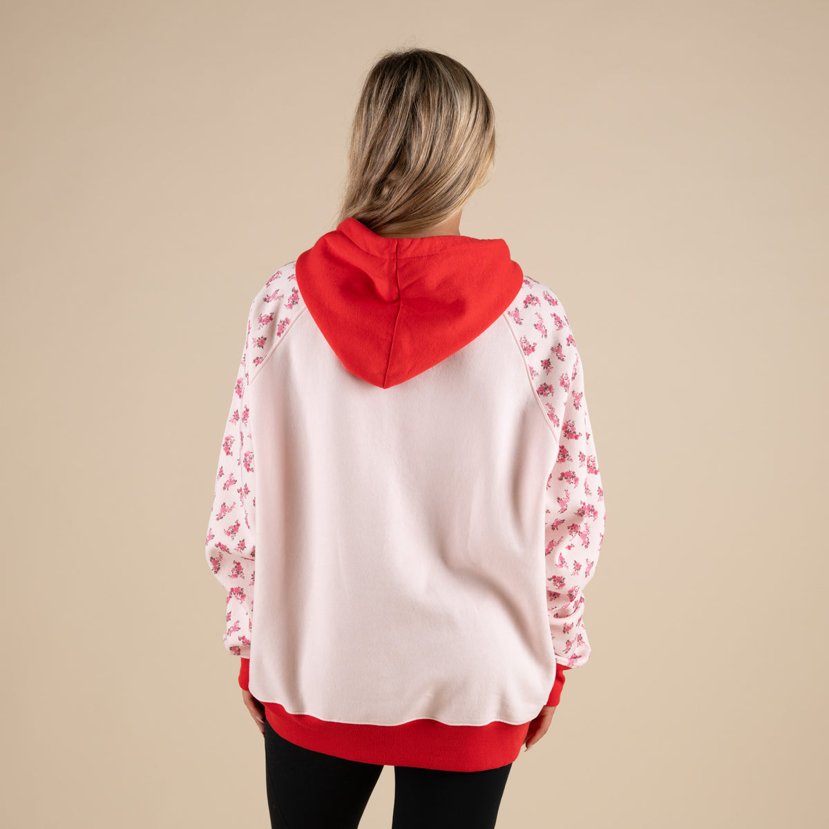 Simply Southern Bow Love Hoodie in Light Pink with contrasting red hood and hem, and floral sleeves.