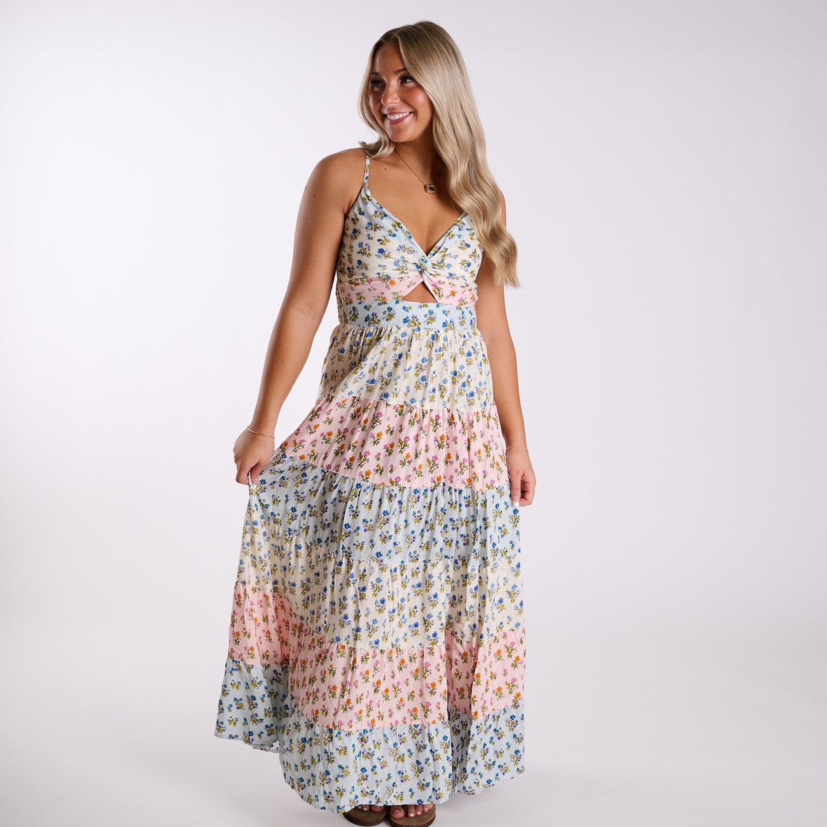 Model wearing Angie blue and pink floral maxi dress with twist-front detail and flowing tiered skirt.