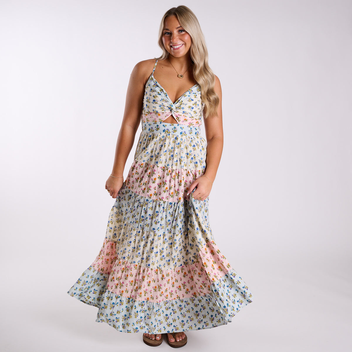 Front view of Angie floral maxi dress with twist-front bodice, small cutout, and tiered blue and pink floral skirt.