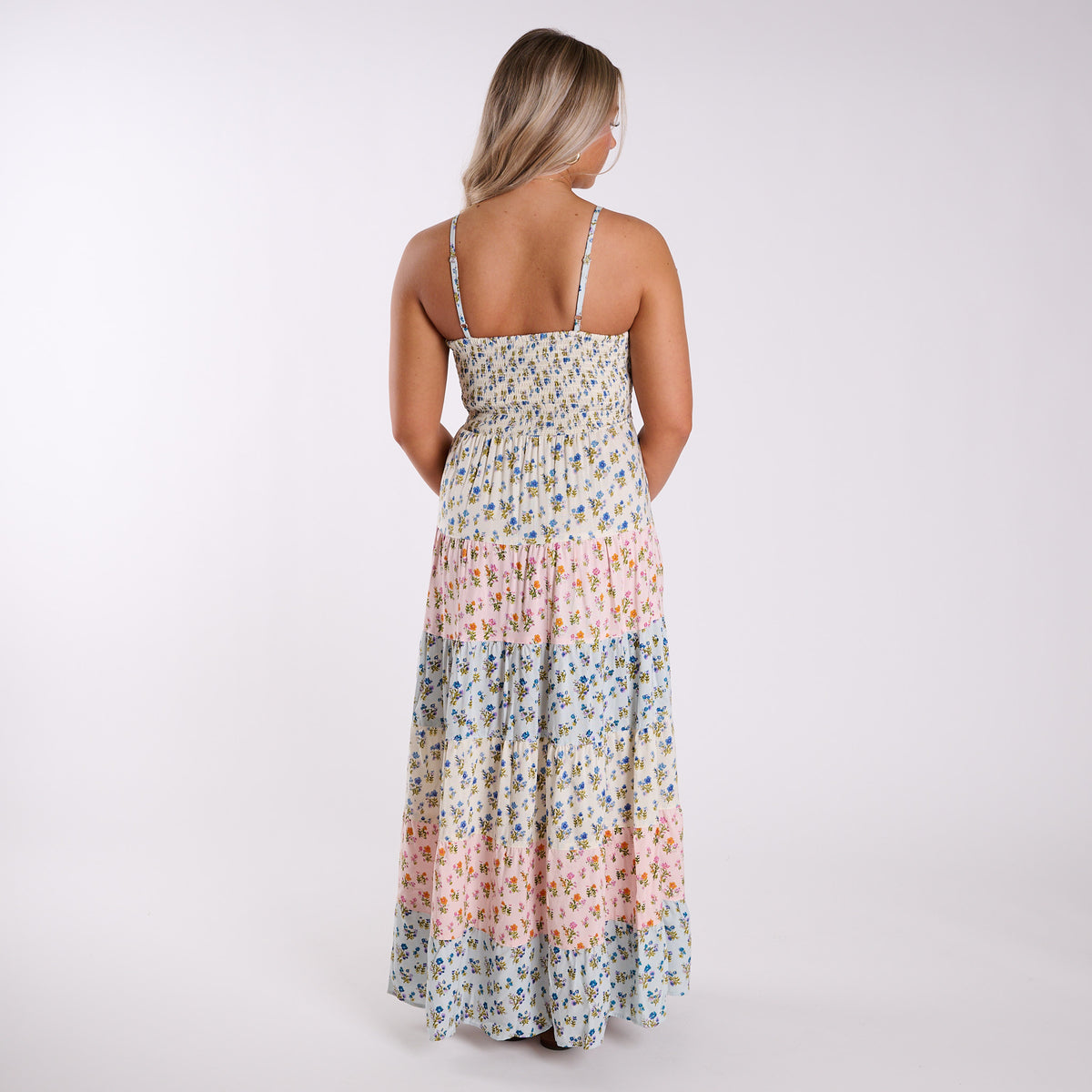 Back view of Angie floral maxi dress with smocked bodice, adjustable straps, and tiered blue and pink floral skirt.
