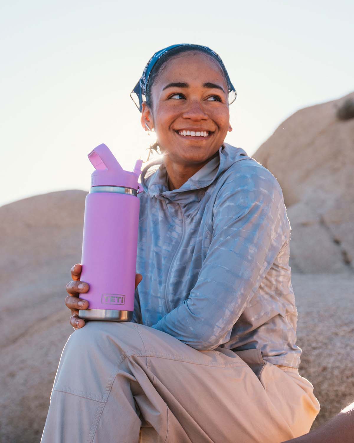 Woman holding a pink yeti water bottle.