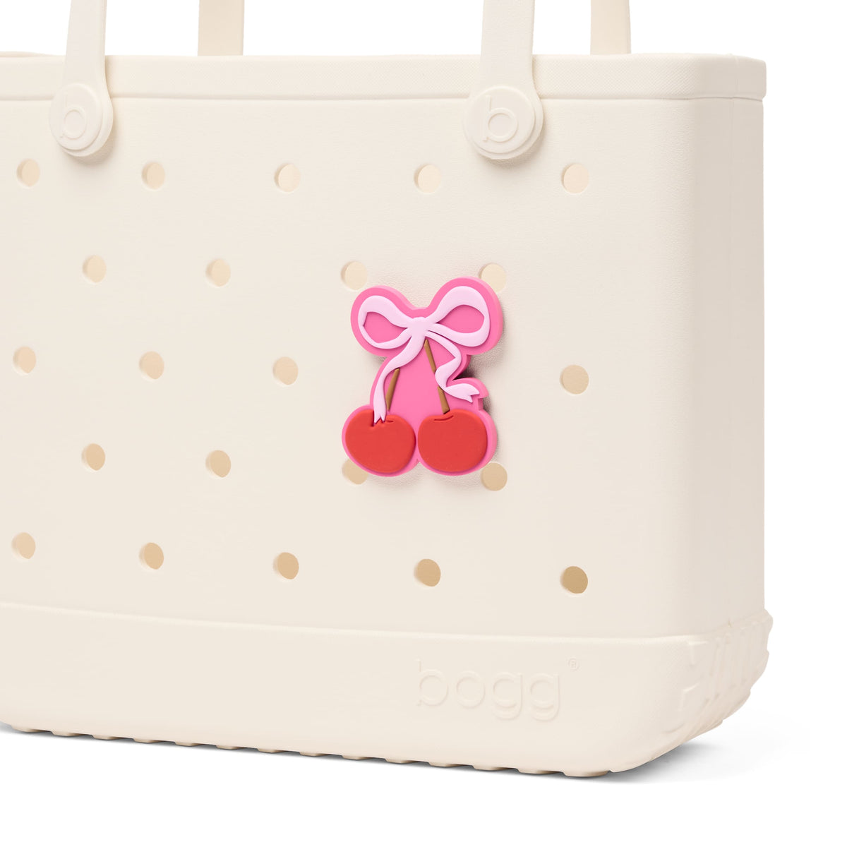 Bogg Bag Bogg Bit cherry charm with pink bow attached to cream Bogg Bag.