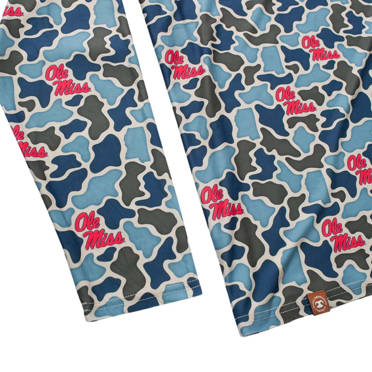 Close-up of sleeves and hem on Ole Miss camo hoodie showing red script logos and brown Amigo Provisions patch near the bottom.