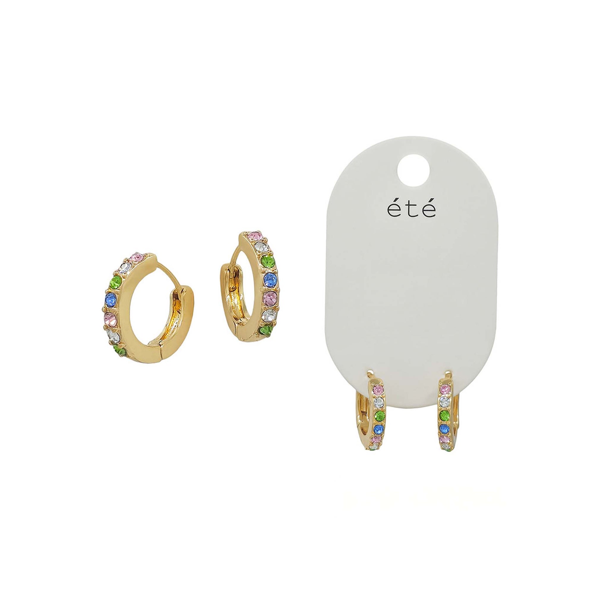 Gold-tone huggie hoop earrings featuring a row of multicolor crystal stones, shown both individually and on a white display card labeled 'été'.