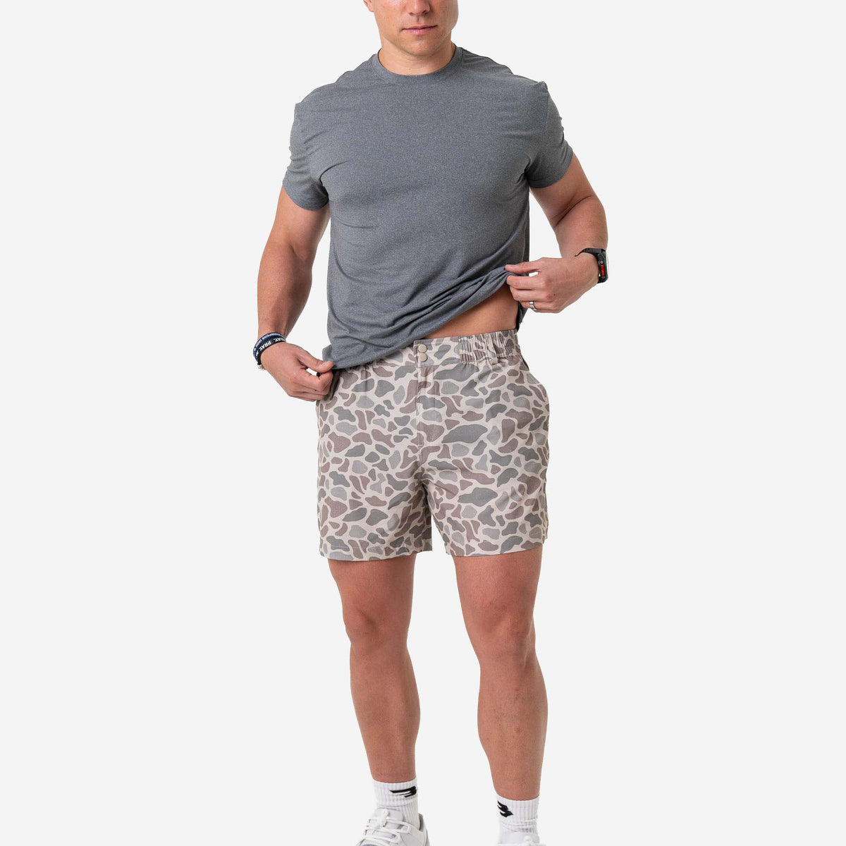 Man wearing Burlebo Everyday Shorts in Classic Deer Camo and a grey t-shirt in front of a white background