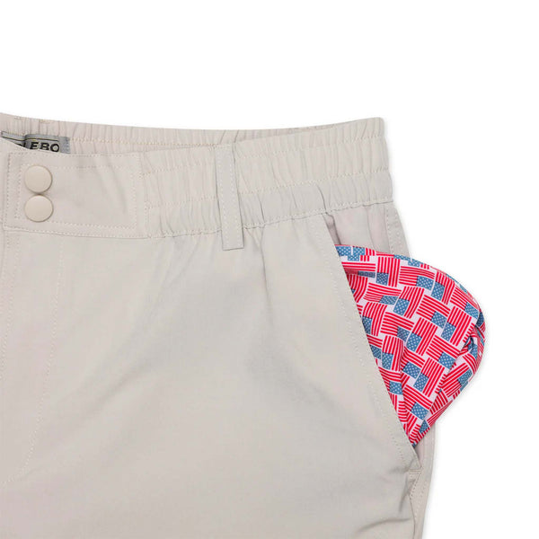 Close-up of Burlebo light khaki shorts with American flag print lining peeking from front pocket.