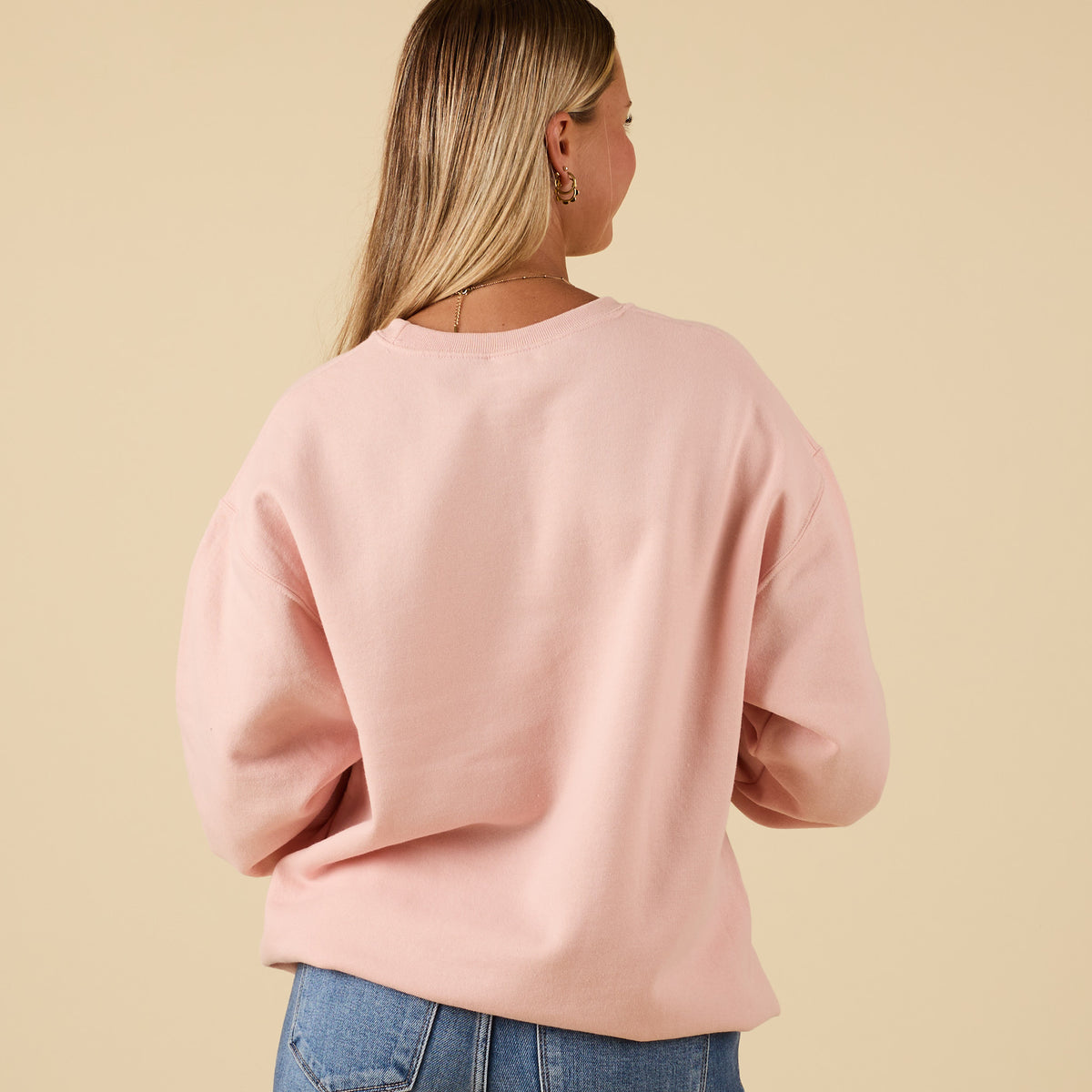 Back view of plain pink crewneck sweatshirt with relaxed fit.