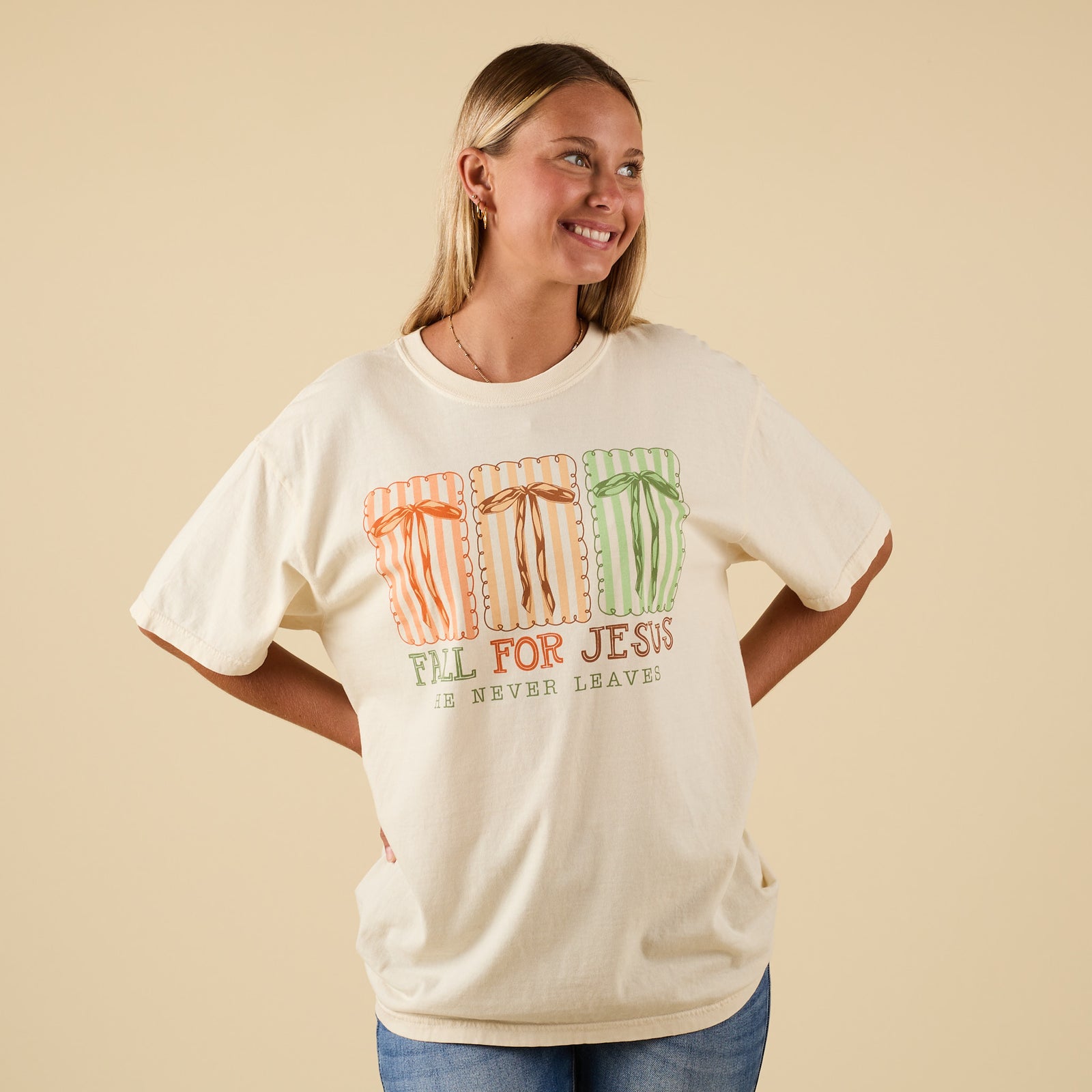 Front view of ivory short sleeve t-shirt with fall-inspired faith graphic and bow design.