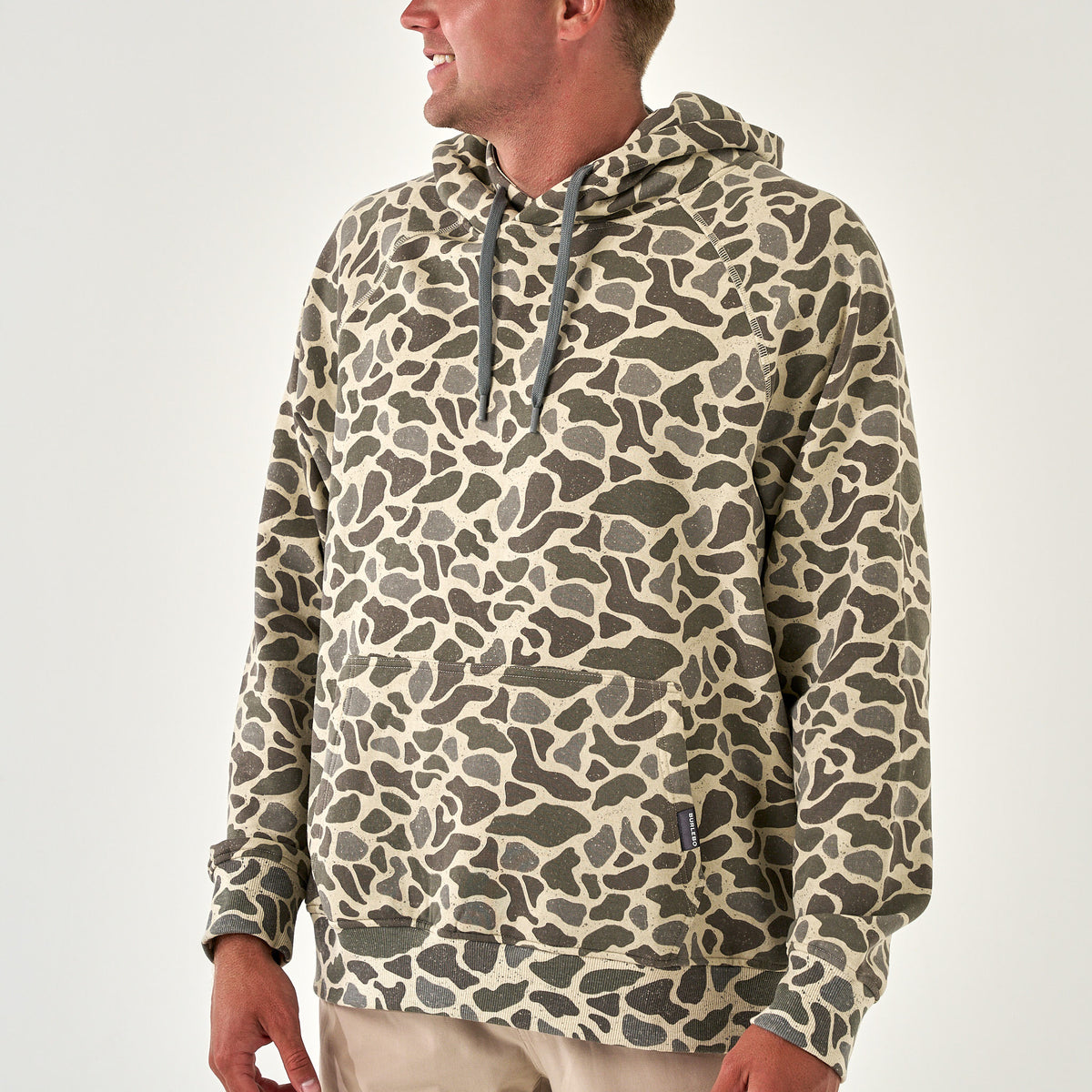 Men’s pullover hoodie in allover tan and dark green camo print with attached hood.
