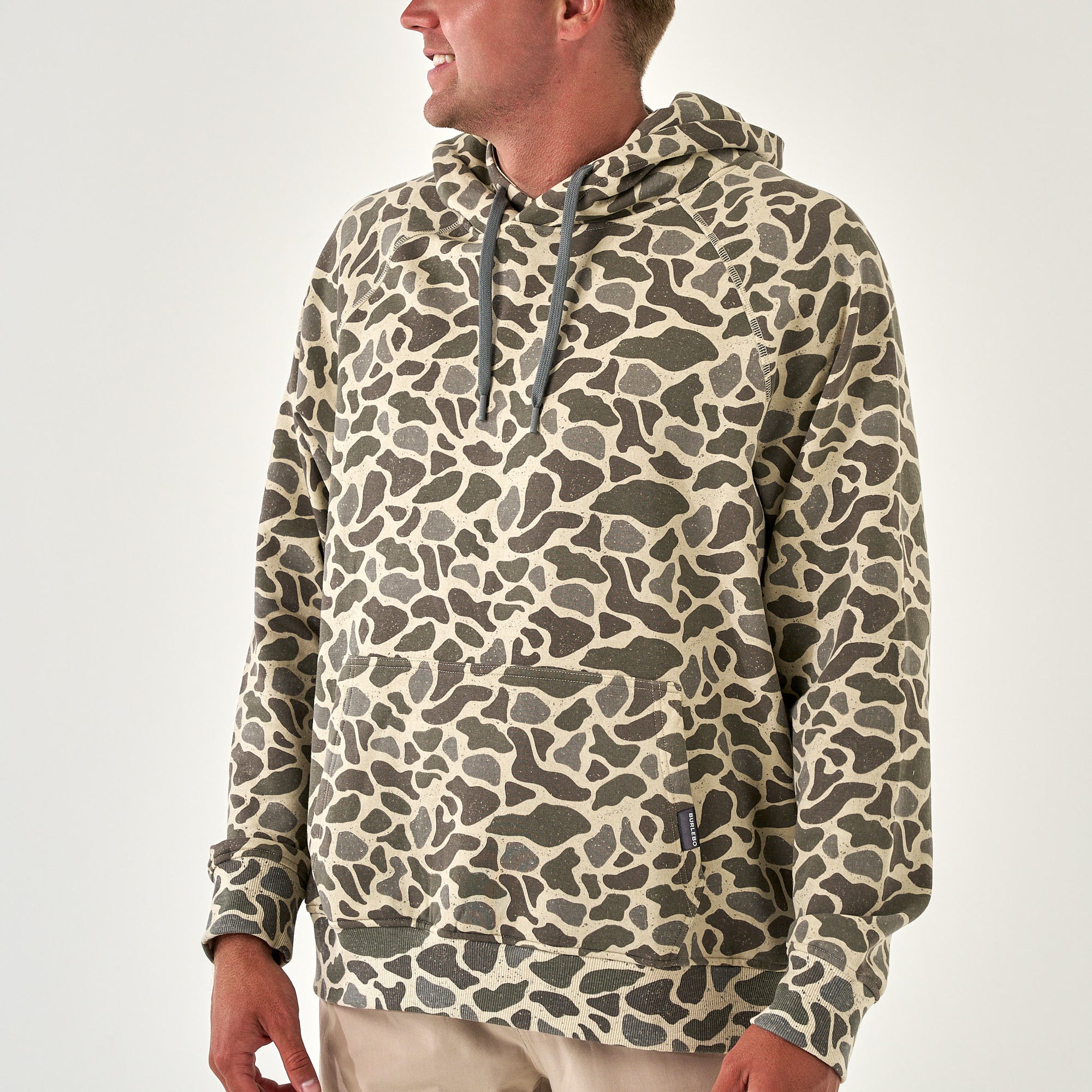 Men’s pullover hoodie in allover tan and dark green camo print with attached hood.