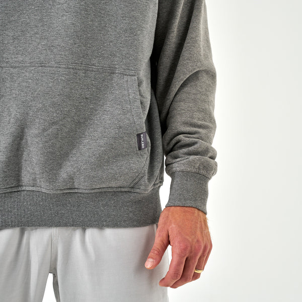 Close-up of Burlebo gray hoodie kangaroo pocket with small Burlebo fabric tag on the hem.