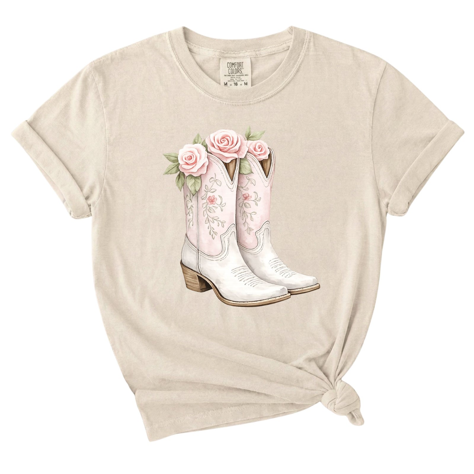 Ivory graphic t-shirt featuring a pair of pink and white floral cowboy boots with roses printed on the front.