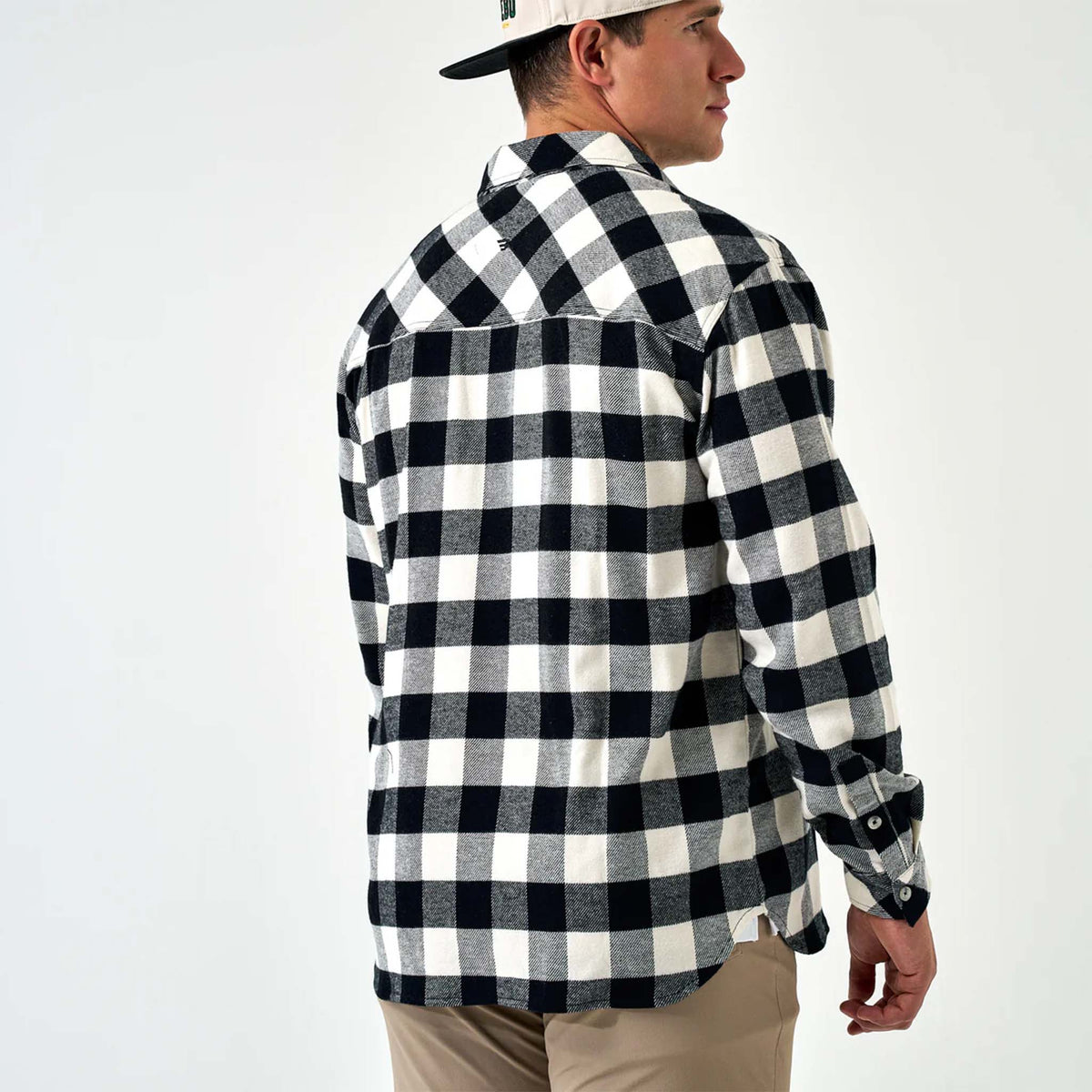 Man wearing a black and white checkered shirt on a white background