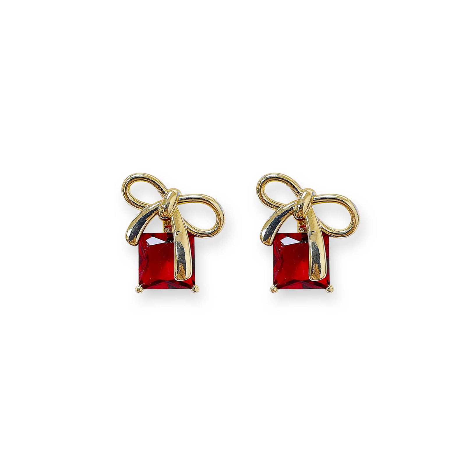 Gold bow-shaped earrings with red gemstones on a white background