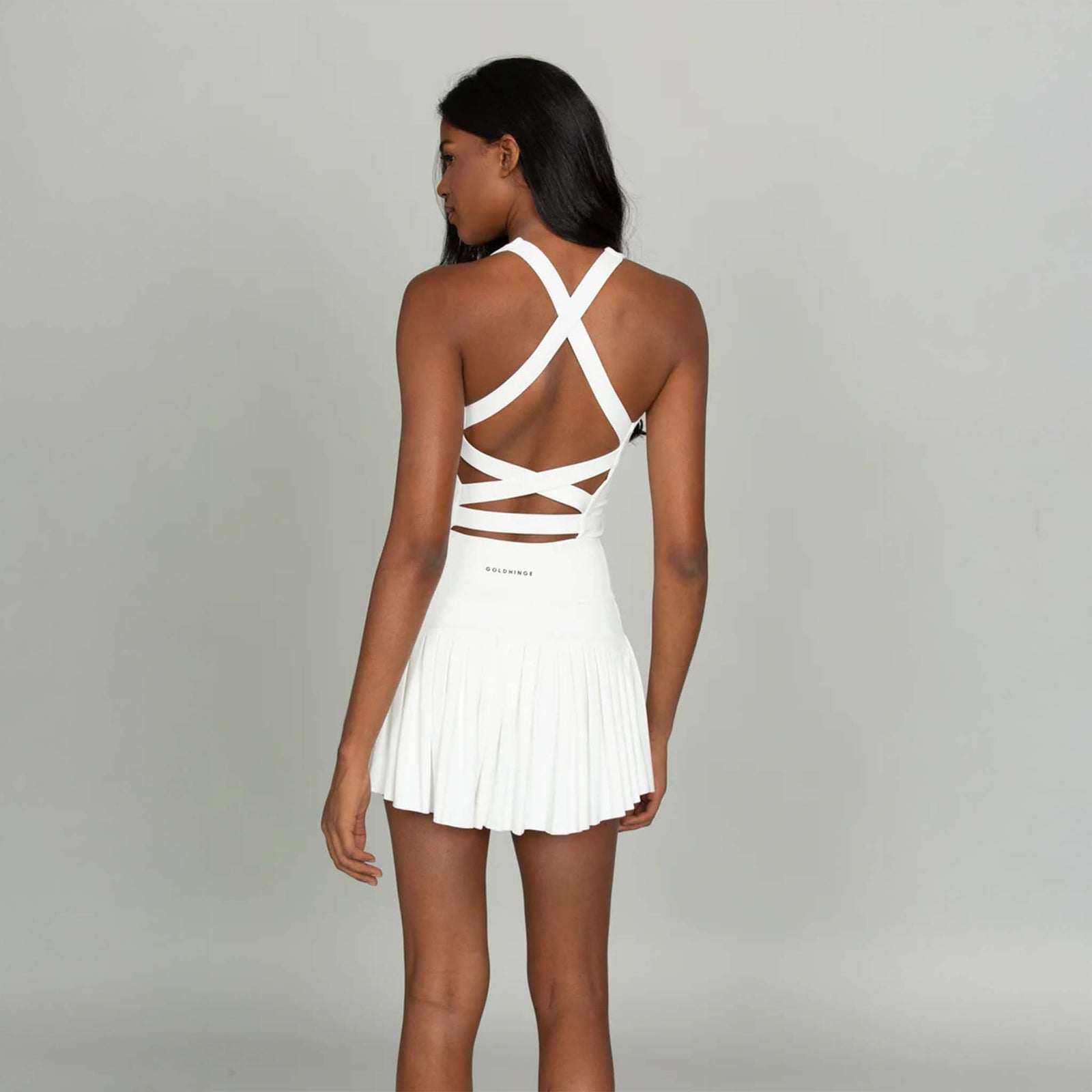 Back view of Gold Hinge white strappy tennis dress with crisscross straps and pleated skirt.