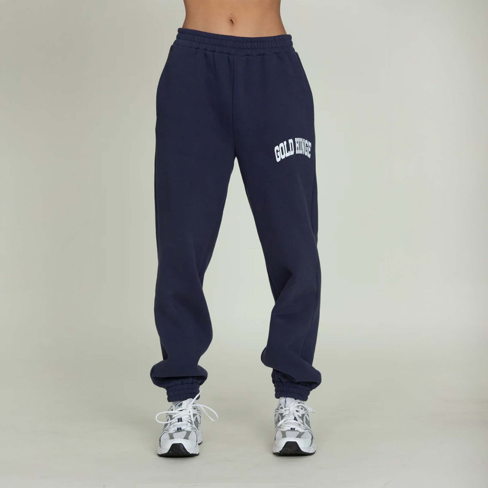 Front view of Gold Hinge jogger sweatpants in denim blue with logo detail and elastic cuffs.