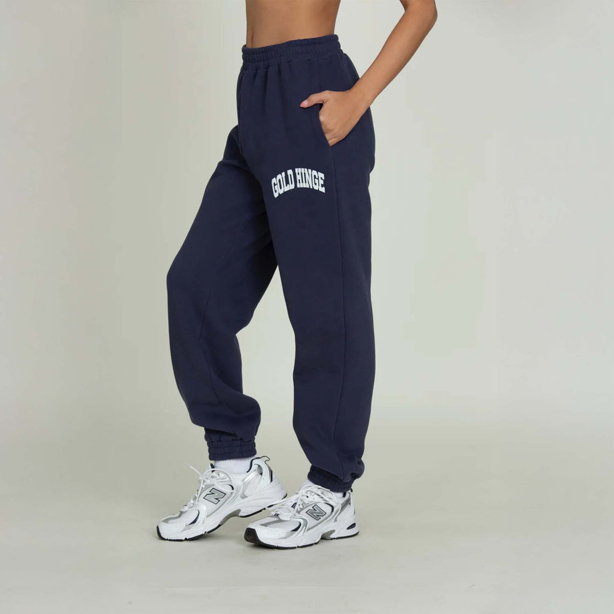Side view of Gold Hinge jogger sweatpants in denim blue with logo detail and elastic cuffs.