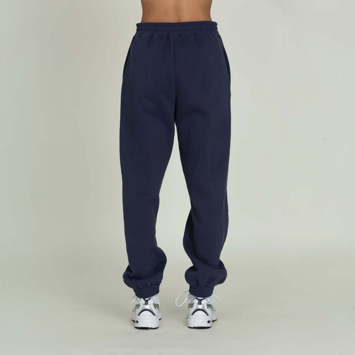 Back view of Gold Hinge jogger sweatpants in denim blue with logo detail and elastic cuffs.