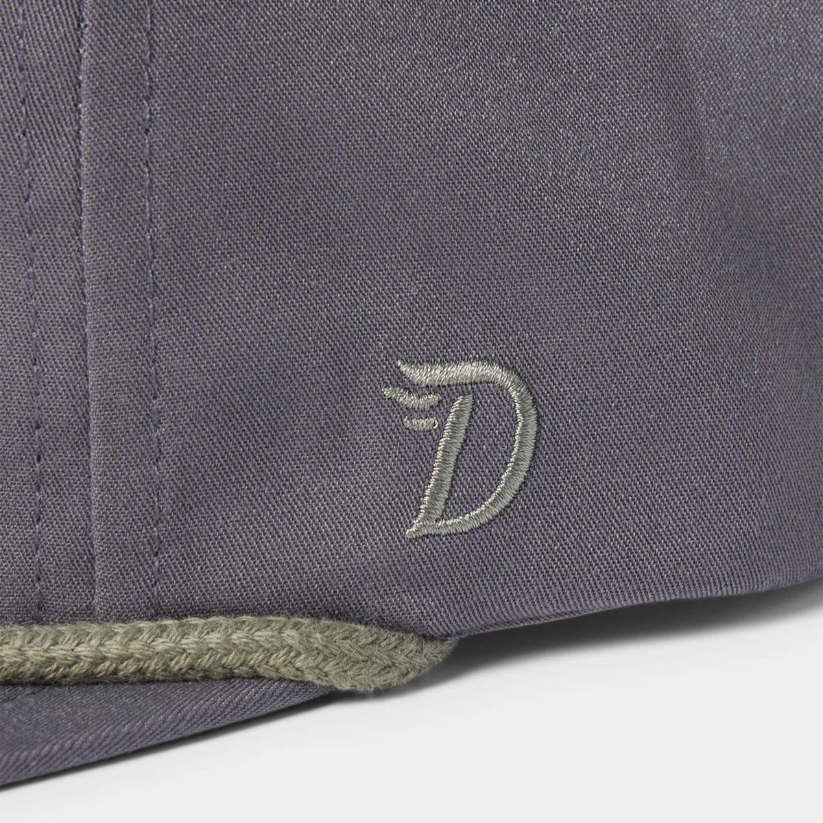 Close up of Duck Camp logo on the side of a charcoal grey hat.