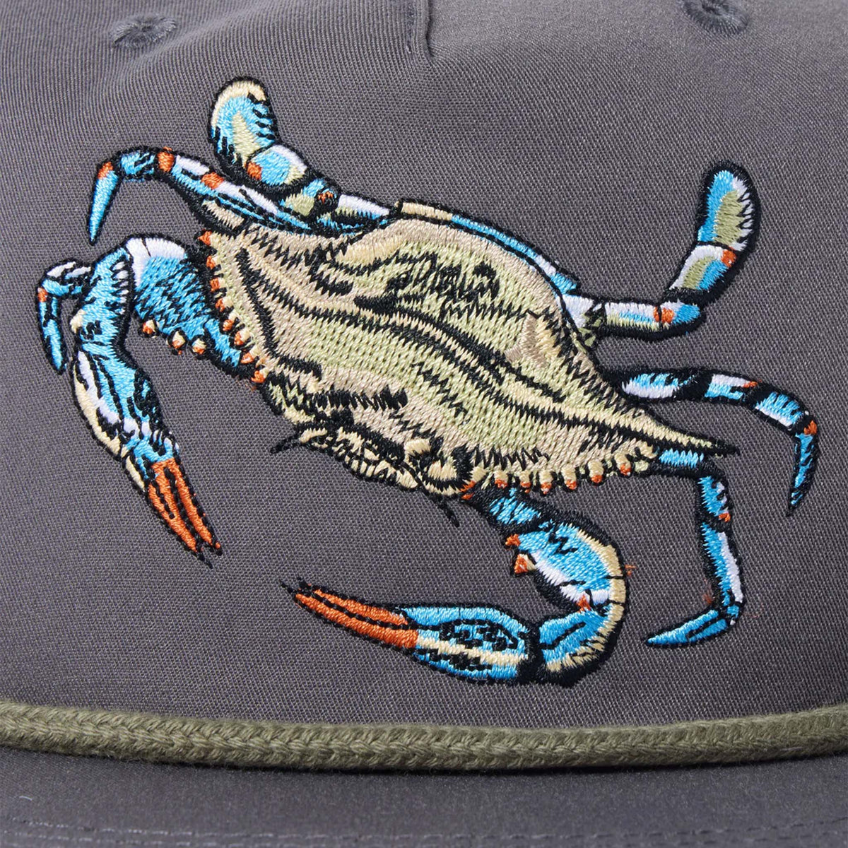 Close up of the embroidered crab on charcoal grey hat.