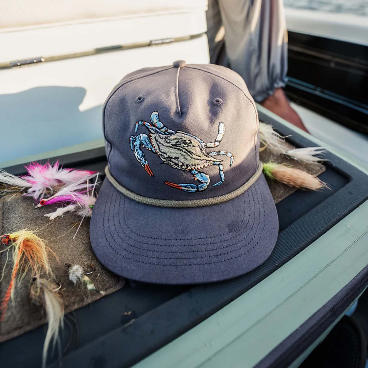 Cap with crab design on a boat with fishing equipment